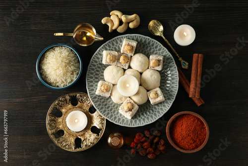 Sweets, spices, rice and candles on dark wooden background, top view