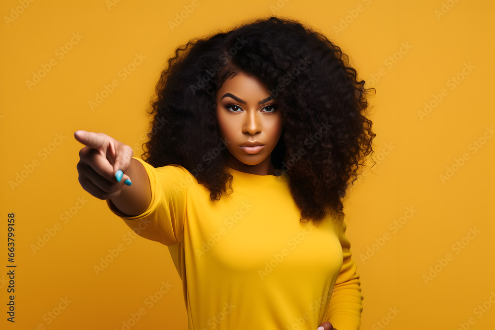 Mujer afroamericana apuntando hacia adelante sobre fondo amarillo publicidad Mujer afroamericana apuntando hacia adelante sobre fondo amarillo publicidad