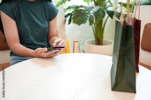 Woman hands holding cell telephone  using smartphone.sale shopping bags. consumerism lifestyle concept in the shopping mall with shopping bag