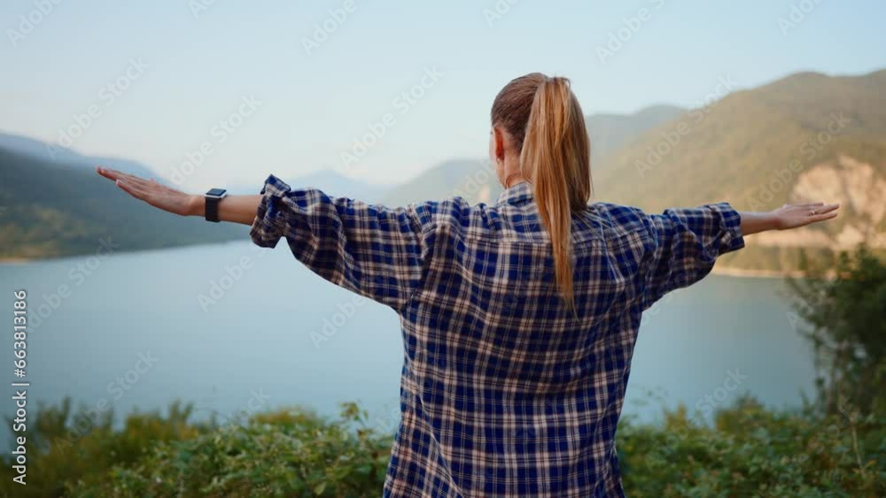 Carefree woman with wide spreaded arms enjoying breathtaking view of river and mountains in wild nature. Girl tourist in hike, back view. Camping, hiking, travel, tourism, vacation, journey concept. Carefree woman with wide spreaded arms enjoying breathtaking view of river and mountains in wild nature. Girl tourist in hike, back view. Camping, hiking, travel, tourism, vacation, journey concept.
