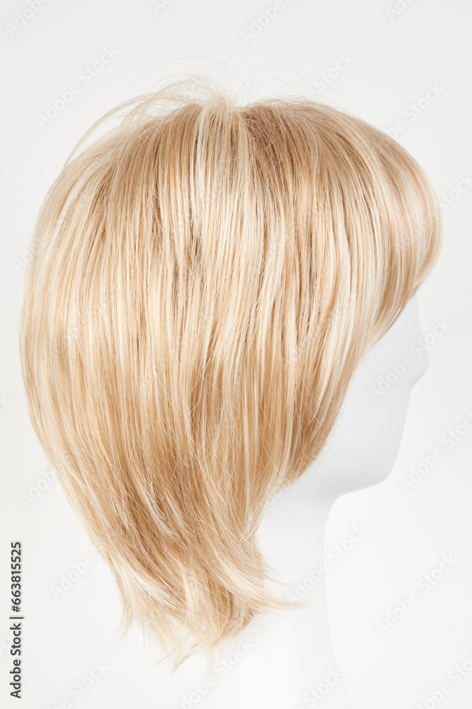 Natural looking blonde fair wig on white mannequin head. Short hair cut on the plastic wig holder isolated on white background, side view. Natural looking blonde fair wig on white mannequin head. Short hair cut on the plastic wig holder isolated on white background, side view.