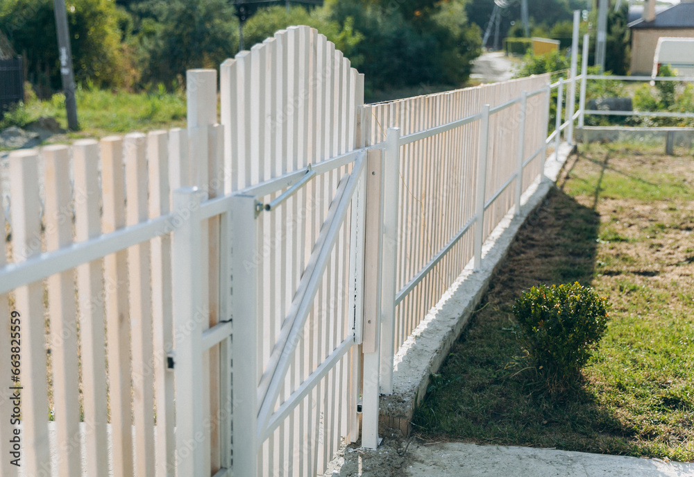 Wooden fence around a beautiful house. fence made of wooden slats. Wooden fence around a beautiful house. fence made of wooden slats.