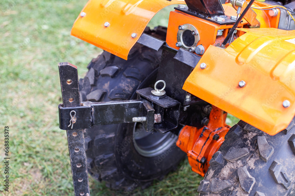 Adjustment of the coupling and attachments in a multifunctional motor cultivator for cottages. Close-up Adjustment of the coupling and attachments in a multifunctional motor cultivator for cottages. Close-up