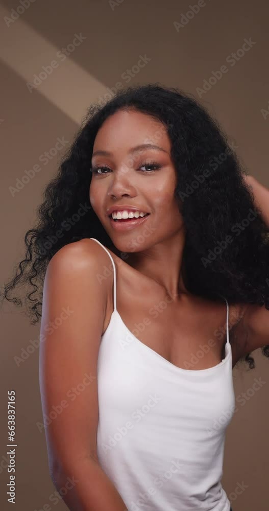 Vertical clip. Portrait of a black girl with curly hair, soft makeup and perfect skin. Beautiful face of young black woman with natural skin. Vertical clip. Portrait of a black girl with curly hair, soft makeup and perfect skin. Beautiful face of young black woman with natural skin.