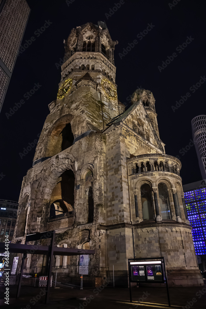 Fototapeta premium New Year's Eve night view of Kaiser Wilhelm Memorial Church with broken spire and New church and belfry on Breitscheidplatz. Berlin, Germany.