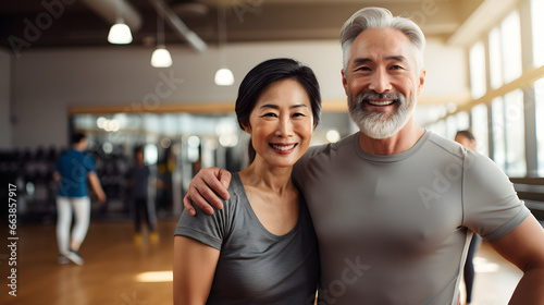 Happy senior mixed korean, asian couple standing together in a gym after exercising