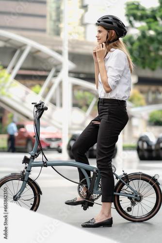 Eco friendly, businesswoman ride bicycle in urban to reduce carbon footprint. Beautiful woman environment preservation person commuting with bicycling. Cycling, alternative transport for green energy.