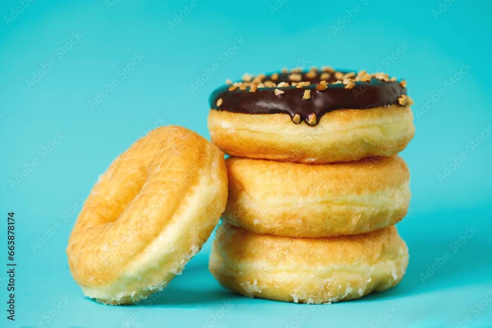 assorted donuts with chocolate frosting, topping sprinkles donuts Colorful variety and Variety of flavors mix of multi colored sweet donuts with frosted sprinkled on blue background. top view assorted donuts with chocolate frosting, topping sprinkles donuts Colorful variety and Variety of flavors mix of multi colored sweet donuts with frosted sprinkled on blue background. top view