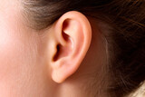 Cropped detail close up photo of the head. female human ear without accessory and hair. Skincare cosmetic treatment.