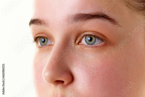 Close-up cropped photo of brunette good-looking female face, eyes, nose. Beauty procedures. Skin care cosmetic treatment.