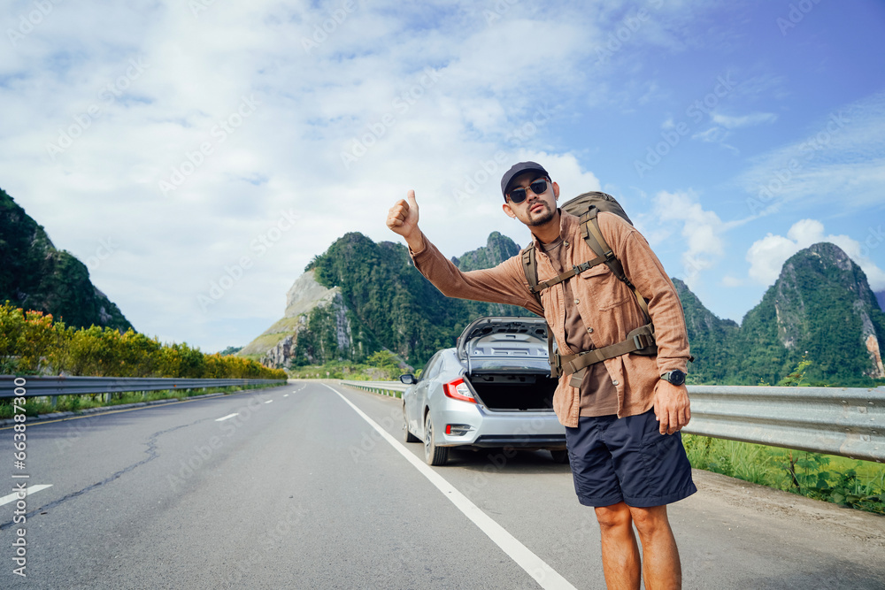 Tourist waving hand asking for help on the highway, Hitchhiking on the road, Travel man hitchhiking Tourist waving hand asking for help on the highway, Hitchhiking on the road, Travel man hitchhiking