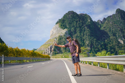 Tourist waving hand asking for help on the highway, Hitchhiking on the road, Travel man hitchhiking