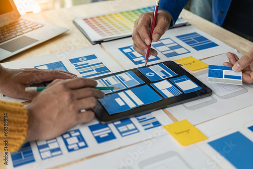 A team of web designers with the ux ui system are writing programs and layers to customize the appearance of the ux ui system and are working together to develop a mobile responsive website.