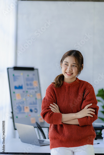 Wallpaper Mural Young Asian accountant working in financial office, managing sales reports using calculator with laptop, preparing reports, calculating balances, documents, tax audit. vertical picture Torontodigital.ca