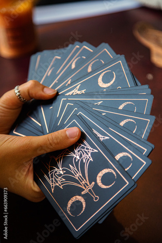 Hands of a woman holding tarot reading cards