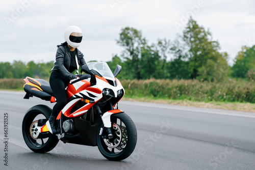 a girl in a leather jacket and a helmet rides a motorcycle. AI GENERATE © ibragimova