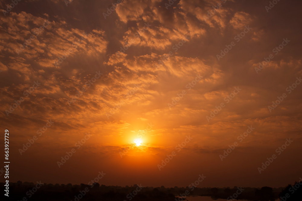 Sunset sky background with clouds and sunbeams. Natural background.