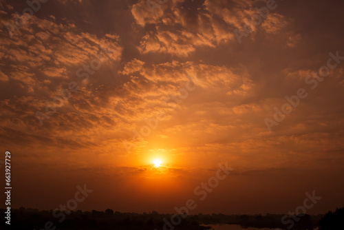 Sunset sky background with clouds and sunbeams. Natural background.