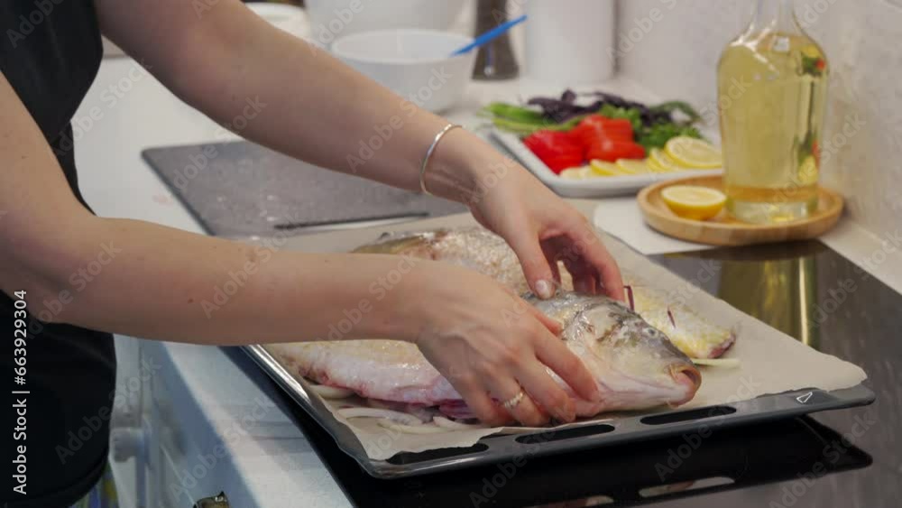 woman preparing to bake whole carp fish in the oven woman preparing to bake whole carp fish in the oven