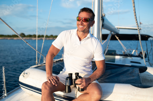 Confident handosme man in sunglasses on a yacht