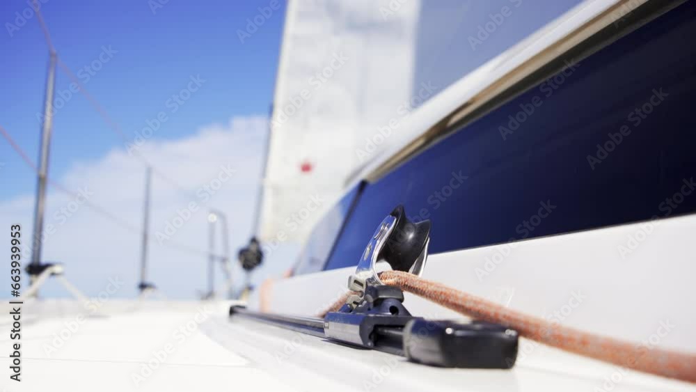 A closeup of the jib sheet on a sailing yacht. A yacht carabiner holds the jib sheet rope