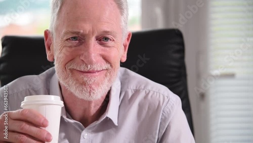 Smiling businessman having coffee break at office