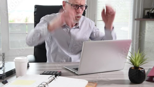 Portrait of an angry businessman working on laptop