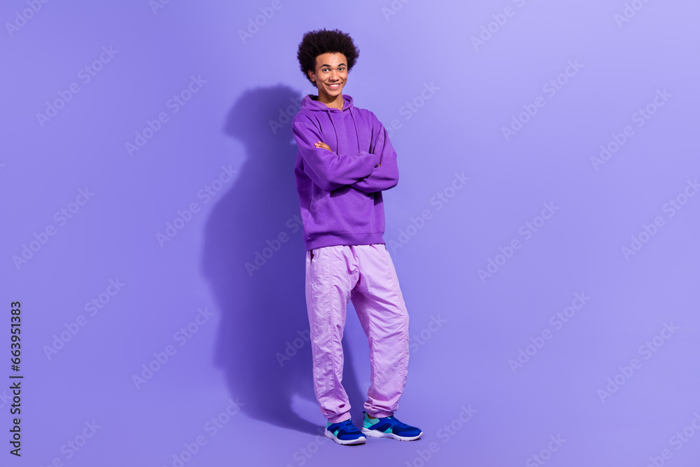 Full size photo of positive nice young person good mood crossed arms posing isolated on violet color background Full size photo of positive nice young person good mood crossed arms posing isolated on violet color background