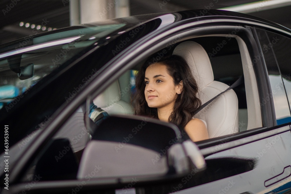 Pretty lady driving a car with her boyfriend on the passenger seat, enjoying summer trip. Travel, lifestyle, transport concept