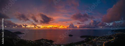 .aerial view lighting in twilight at Kata beaches and Karon beach..stunning cloud moving in colorful sky at twilight above the islands..panorama beautiful yellow reflection on sea surfect background.