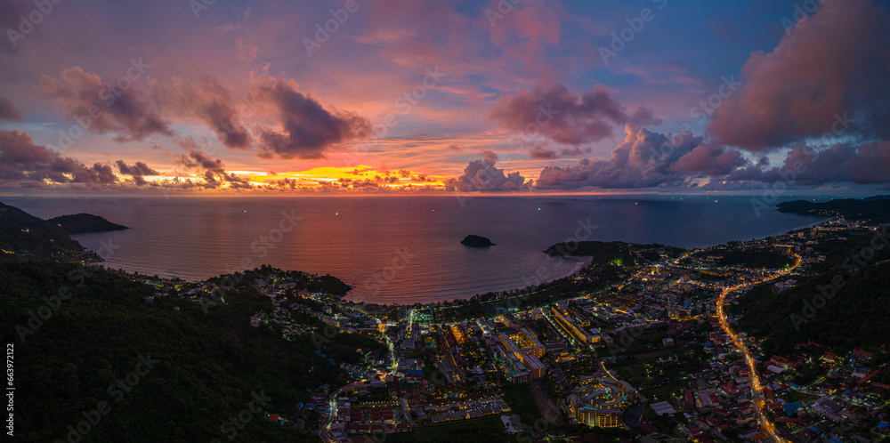 .aerial view lighting in twilight at Kata beaches and Karon beach..stunning cloud moving in colorful sky at twilight above the islands..panorama beautiful yellow reflection on sea surfect background.