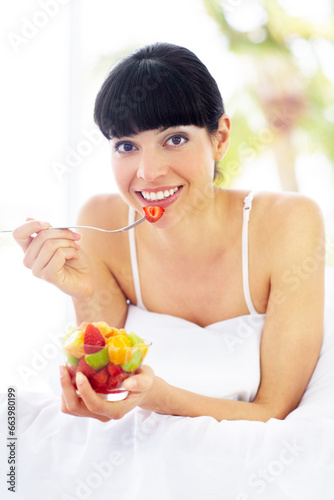 Fruit salad, home bed and portrait of happy woman with organic meal, snack or morning breakfast for healthy lifestyle balance. Apartment bedroom, strawberry benefits or relax person eating vegan food
