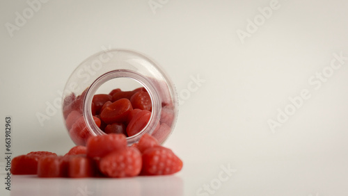 Biotin Gummies for Hair, Skin, and Nails spilling out from the bottle, showcased against a gentle off-white background.