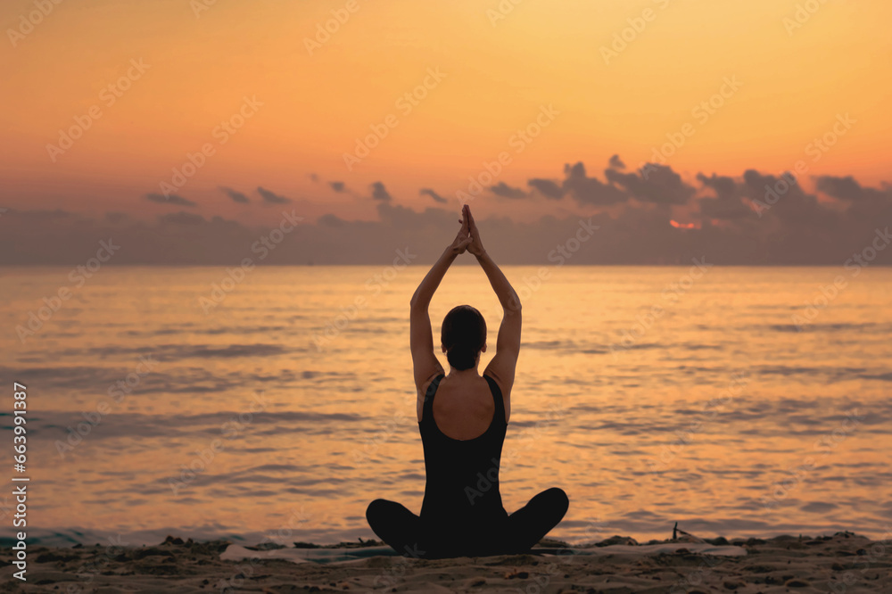  young girl practicing yoga at the beach at sunrise