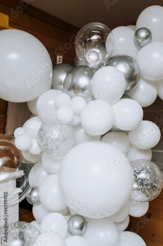 Festive photo zone made of white and gray balloons indoors. Close-up photography, background, holiday concept.