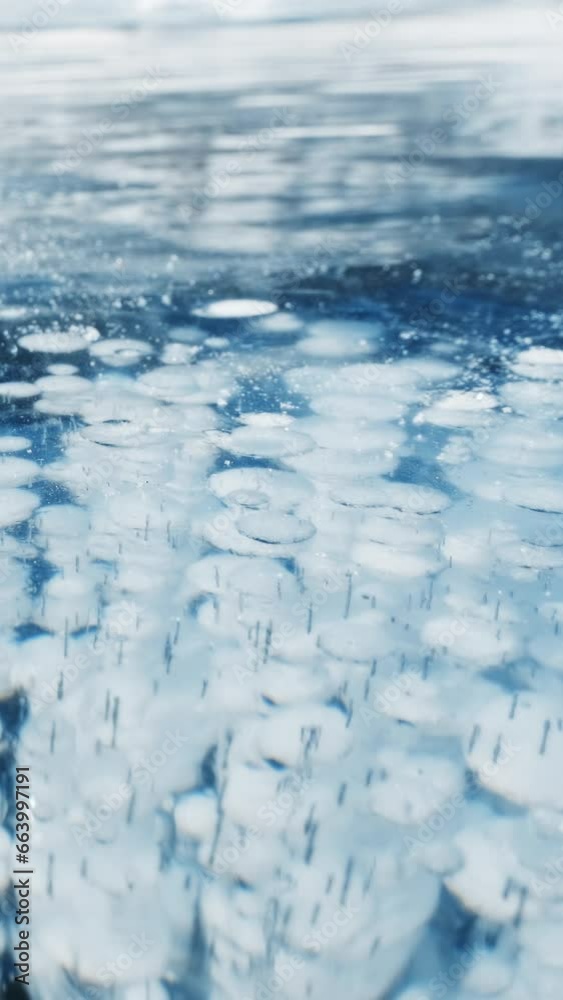 Beautiful transparent blue ice and frozen methane bubbles on Baikal Lake background texture. Vertical video Beautiful transparent blue ice and frozen methane bubbles on Baikal Lake background texture. Vertical video