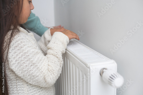 hands of a little girl near the radiator