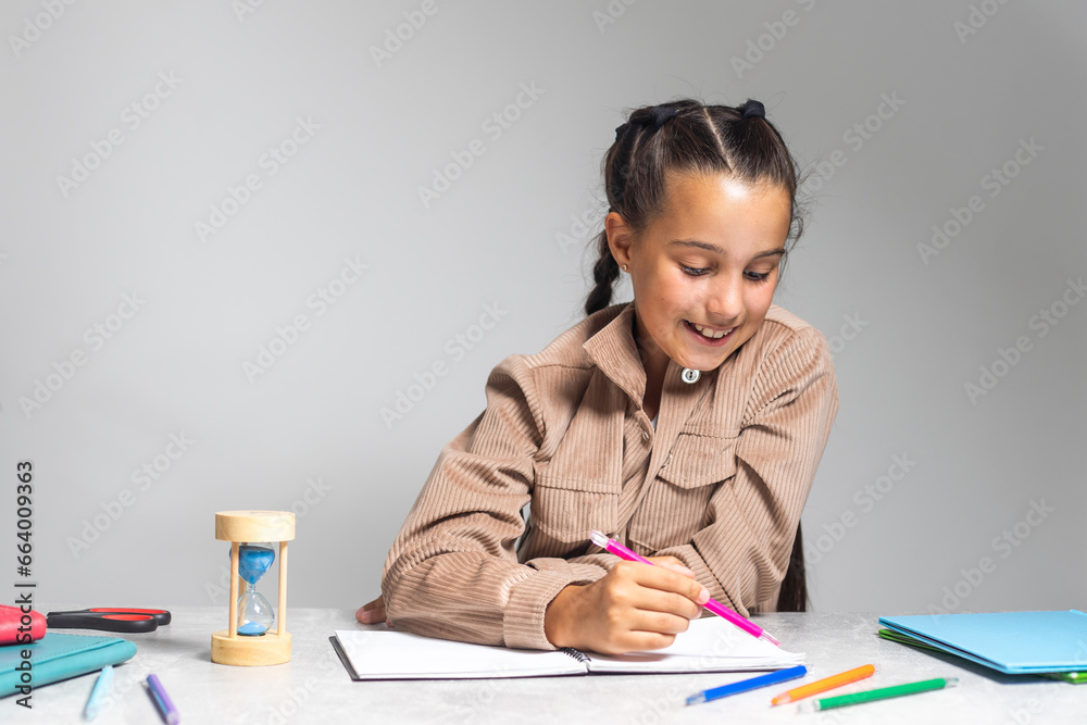 Smart small Caucasian girl child sit at table at home write in exercise book prepare homework for school. education concept. Smart small Caucasian girl child sit at table at home write in exercise book prepare homework for school. education concept.
