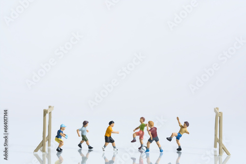 Children playing football, miniature figures scene, white background, copy space
