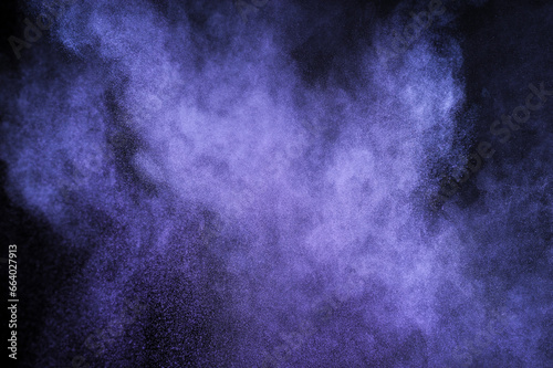 Purple powder explosion on black background. Mauve color cloud. Violet dust explode. Freeze motion paint Holi.