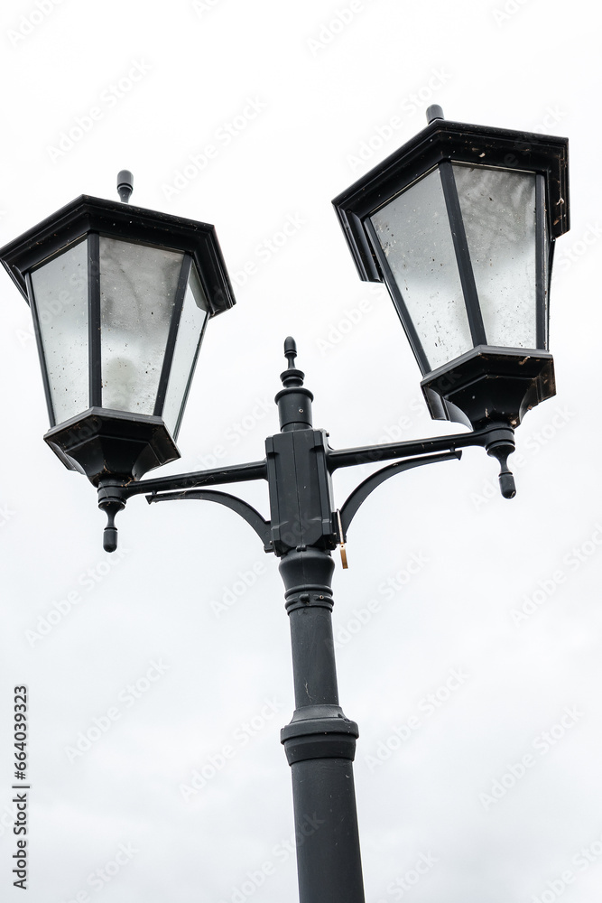 street lamppost with four lighting fixtures against the sky