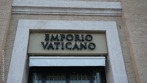 Close-up low-angle view of street name sign of Emporio Vaticano on wall of old house in Rome, Italy, Piazza Pio XII. Concept of vacations and travel. Shooting in slow motion. photo
