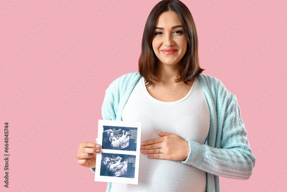 Young pregnant woman with sonogram image on pink background Young pregnant woman with sonogram image on pink background