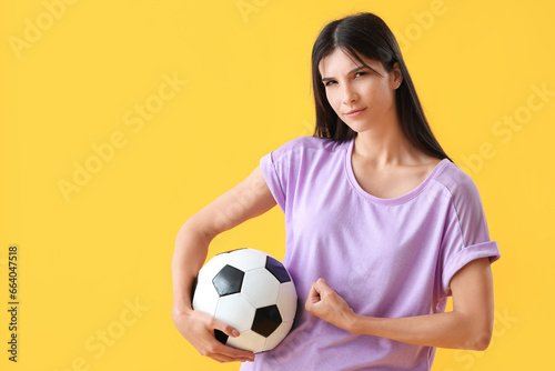 Sporty young woman with soccer ball on yellow background © Pixel-Shot