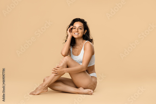 Love Yourself. Beautiful Woman In Underwear Sitting On Floor Over Beige Background