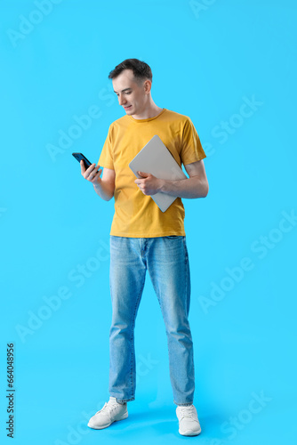 Young man with laptop and m...