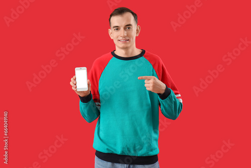 Young man pointing at mobil...