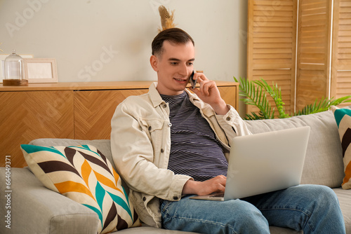 Young man with laptop talki...