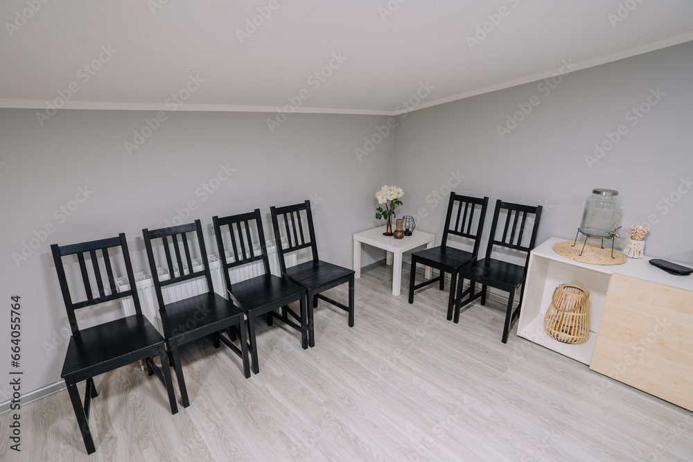 Black leather chairs lined up against a wall in a waiting area