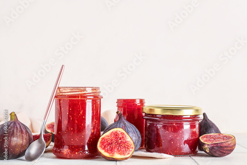 Jars of sweet fig jam on white tile table